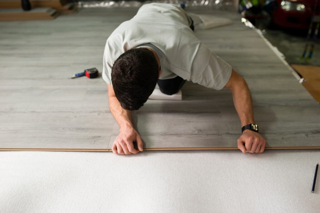 Young man placing a laminate floor